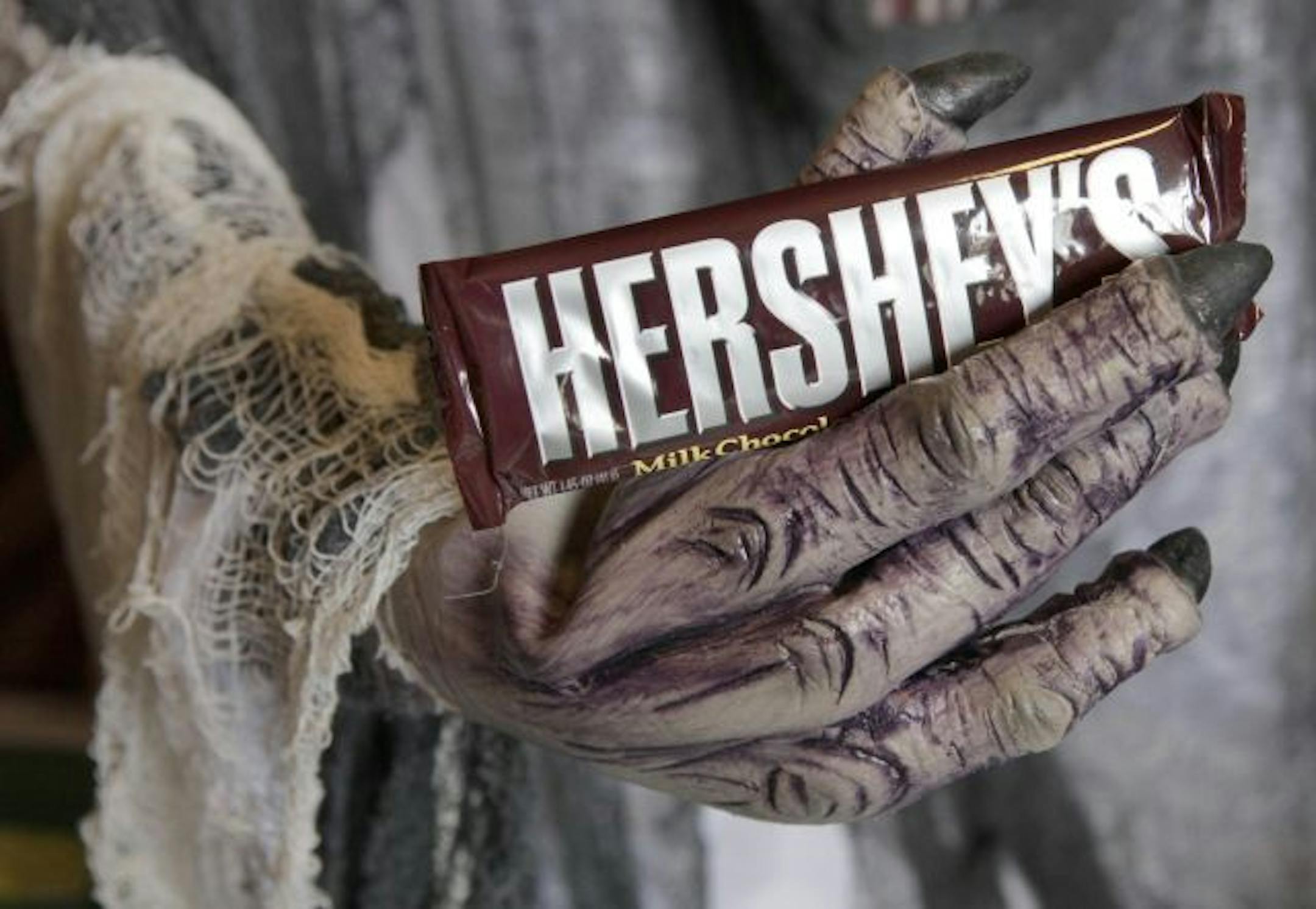 FILE- This Oct. 21, 2009 file photo shows a Hershey chocolate bar in the hand of a Halloween creature at a display inside Chagrin Hardware in Chagrin Falls, Ohio.