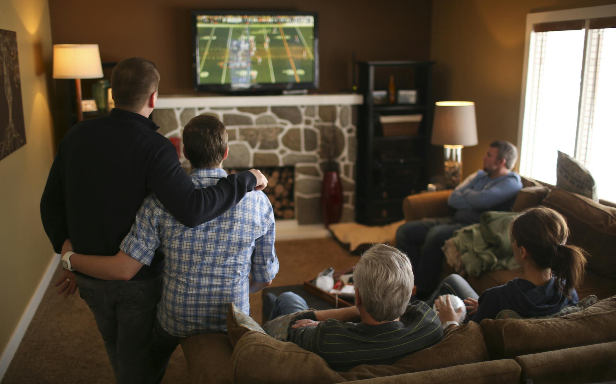 Tyler and Thom Bieniek hosted a gathering of Tyler's family Sunday afternoon, January 19, 2014 in their Sartell home to celebrate Thom successfully passing his nursing board exam. As family members began to arrive, Tyler, left, and Thom and the others watched an NFL playoff game before dinner. ] JEFF WHEELER ‚Ä¢ jeff.wheeler@startribune.com