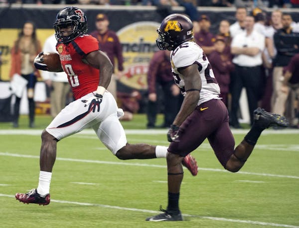 Texas Tech's Eric Ward, left, outruns Minnesota's Jeremy Baltazar, right, for a touchdown during the fourth quarter of the Meineke Car Care Bowl NCAA 