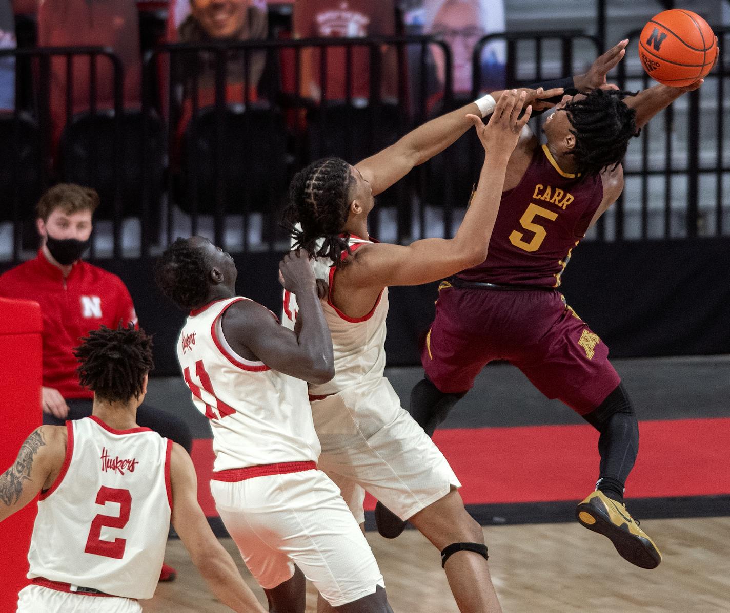 Minnesota's Marcus Carr (5) gets fouled by Nebraska forward Derrick Walker as Lat Mayen (11) defends during the second half of an NCAA college basketball game Saturday, Feb. 27, 2021, in Lincoln, Neb. (Francis Gardler/Lincoln Journal Star via AP)