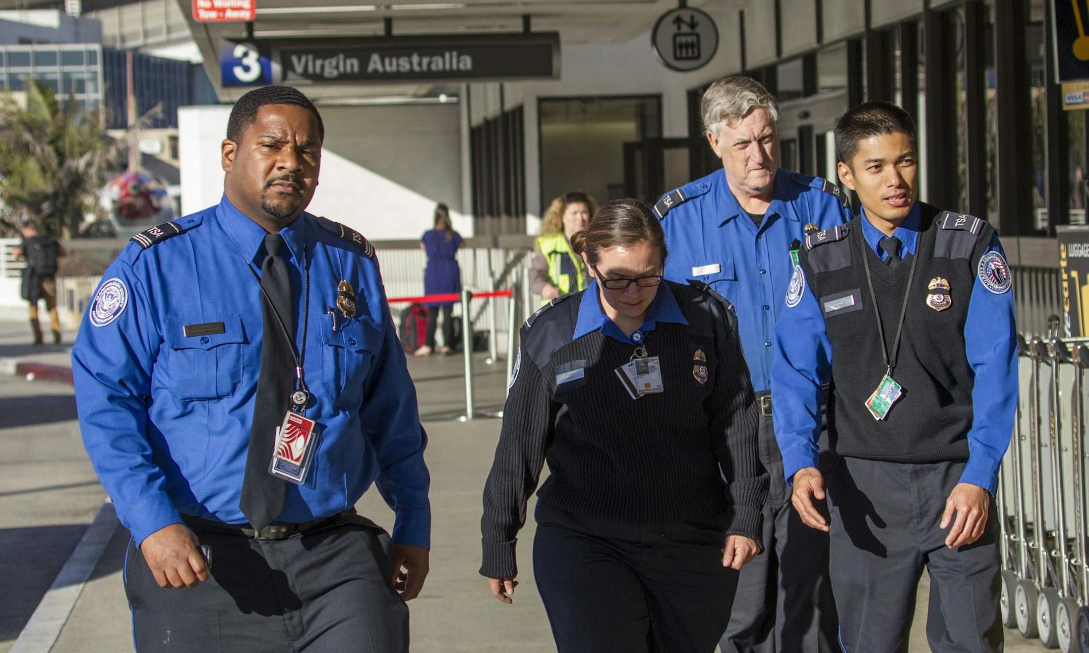 Transportation Security Administration employees wear black ribbons over their badges on Saturday, Nov. 2, 2013, at Los Angeles International Airport. A gunman armed with a semi-automatic rifle opened fire at the airport on Friday, killing a Transportation Security Administration employee and wounding two other people in an attack that frightened passengers and disrupted flights nationwide. (AP Photo/Ringo H.W. Chiu)