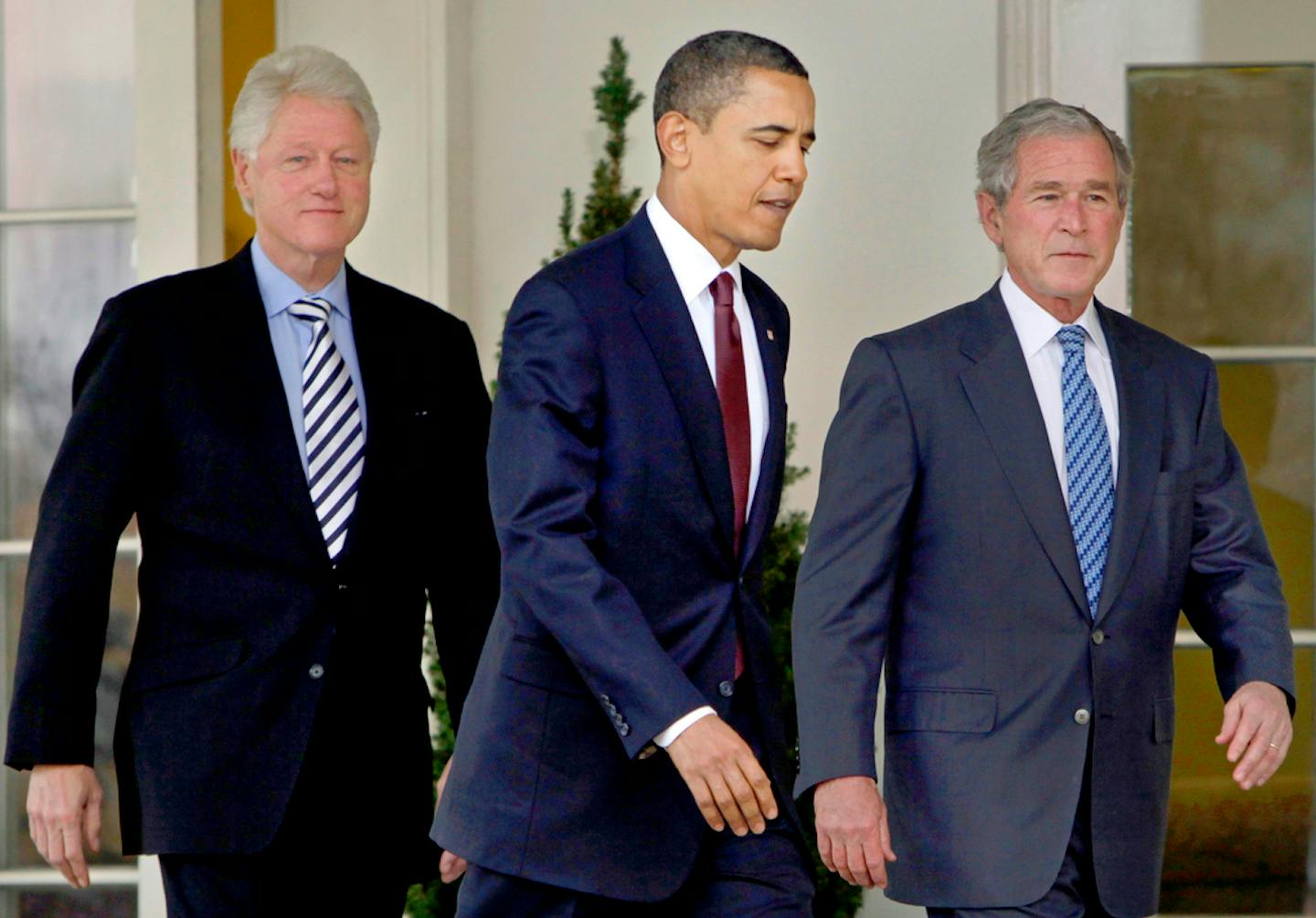 FILE - In this Jan. 16, 2010, file photo President Barack Obama, center, walks out of the Oval Office of the White House with former Presidents Bill Clinton, left, and George W. Bush, right, to deliver remarks in the Rose Garden at the White House in Washington. Three former presidents say they'd be willing to take a coronavirus vaccine publicly, once one becomes available, to encourage all Americans to get inoculated against a disease that has already killed more than 273,000 people nationwide.