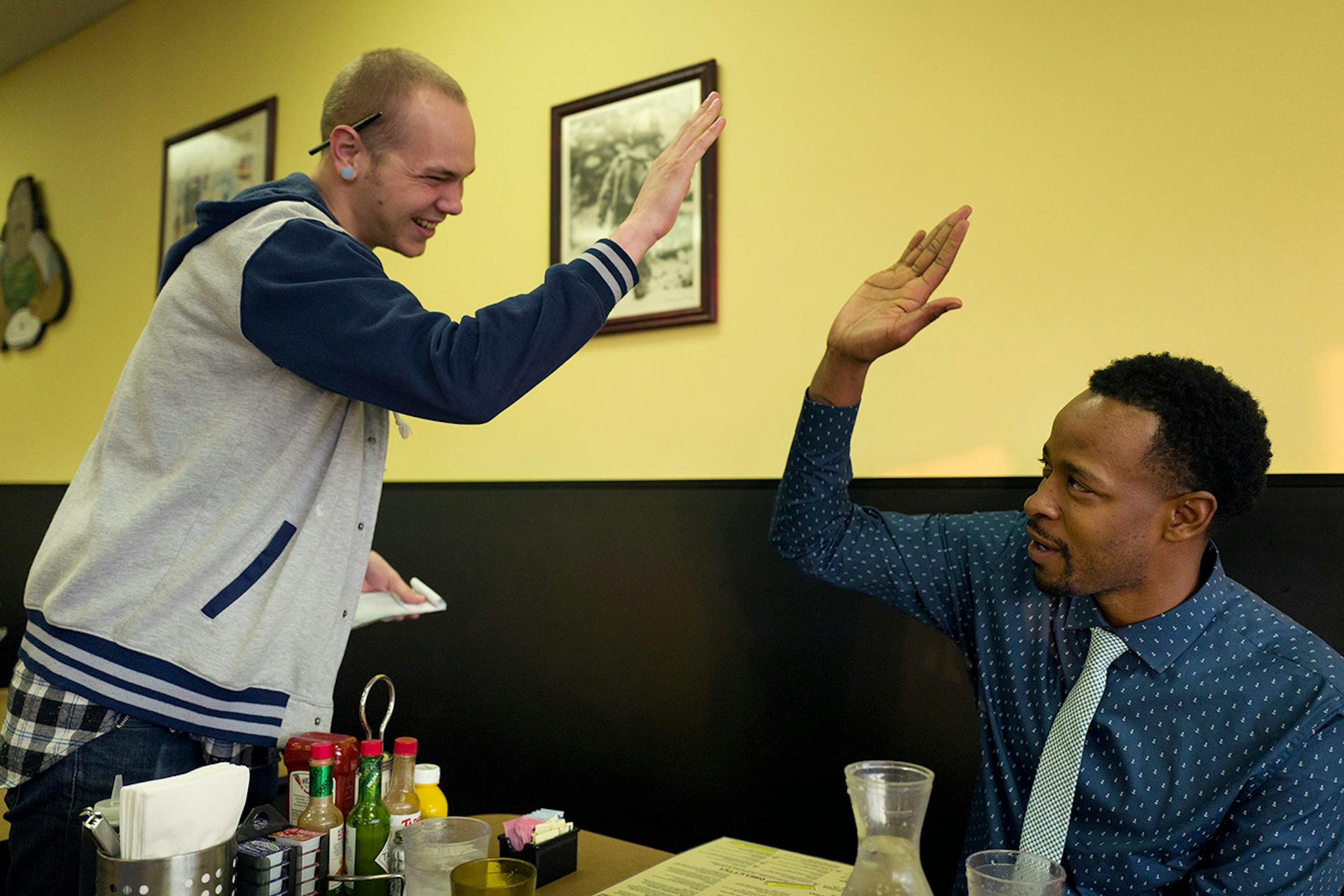 Jacob Johnson high-fived Abdul Wright at Fat Nat's restaurant in New Hope on Monday after he heard that Wright had won the 2016 Minnesota Teacher of the Year award.