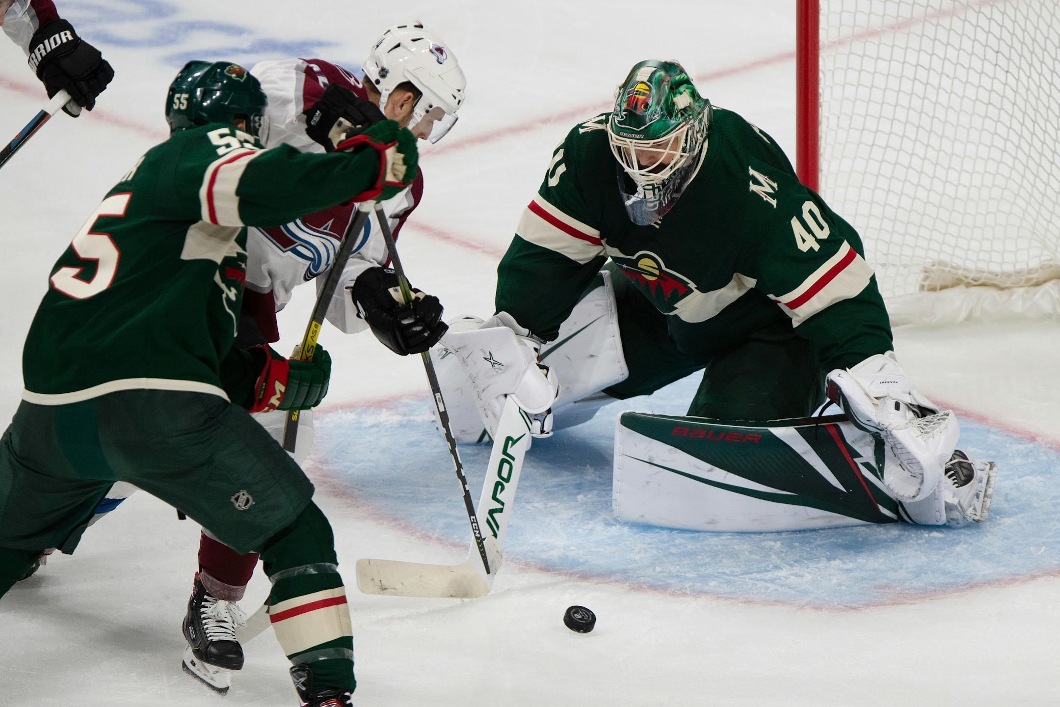 Minnesota Wild goalie Devan Dubnyk watches the puck as Colorado Avalanche's A.J. Greer tries to shoot it into the net during the first period of an NHL hockey game Saturday, Sept. 21, 2019, in St. Paul, Minn. (AP Photo/Stacy Bengs)