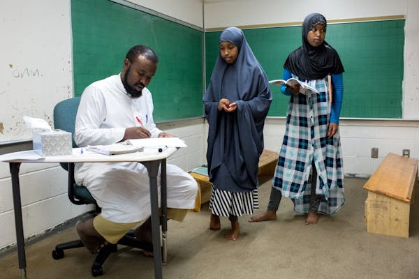Amal (center) and Hamda Abdikader practice Arabic with Muse Hussein during class at the Dar Al Farooq Islamic Center, on Monday.