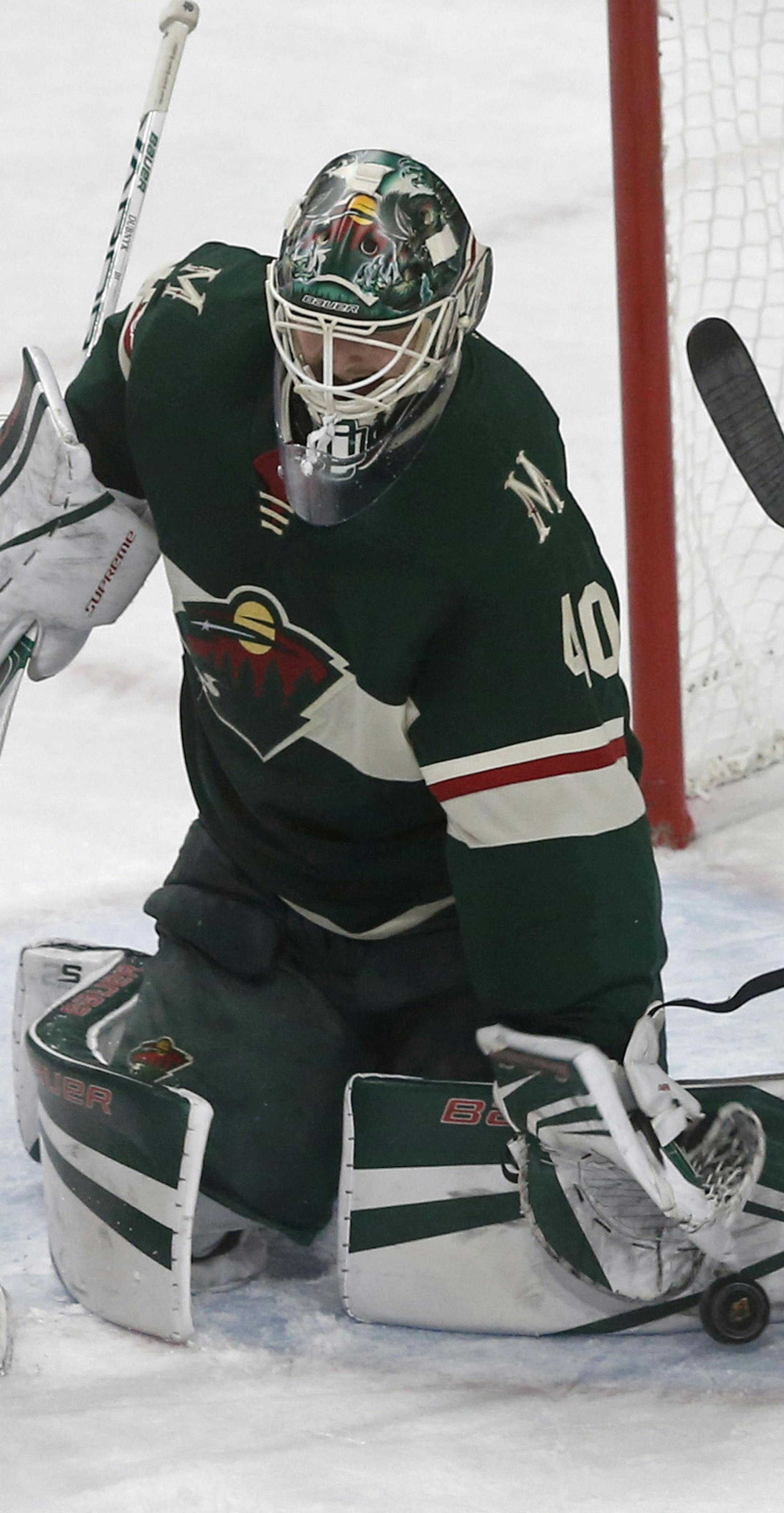 Minnesota Wild's Zack Mitchell, center, keeps New York Islanders' Anthony Beauvillier, left, away from a rebound as Wild goalie Devan Dubnyk stops a shot during the third period of an NHL hockey game Thursday, Oct. 26, 2017, in St. Paul. Minn. (AP Photo/Jim Mone)