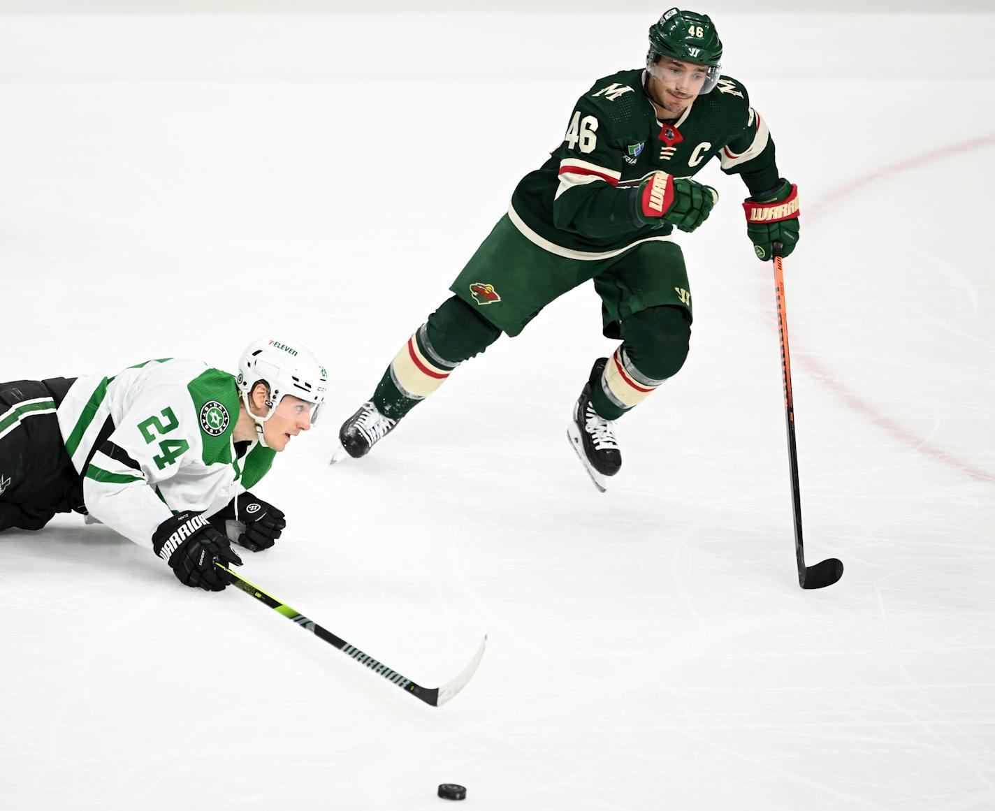 Dallas Stars center Roope Hintz (24) loses control of the puck as he's pursued by Minnesota Wild defenseman Jared Spurgeon (46) during the second period of an NHL hockey game Thursday, Dec. 29, 2022 at the Xcel Energy Center in St. Paul, Minn... ] AARON LAVINSKY • aaron.lavinsky@startribune.com