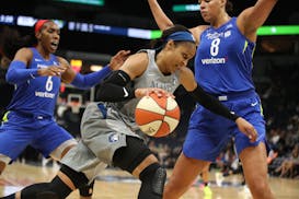The Minnesota Lynx's Maya Moore dribbles past the Dallas Wings' Kayla Thornton, left, and Liz Cambage at Target Center in Minneapolis on Tuesday, June