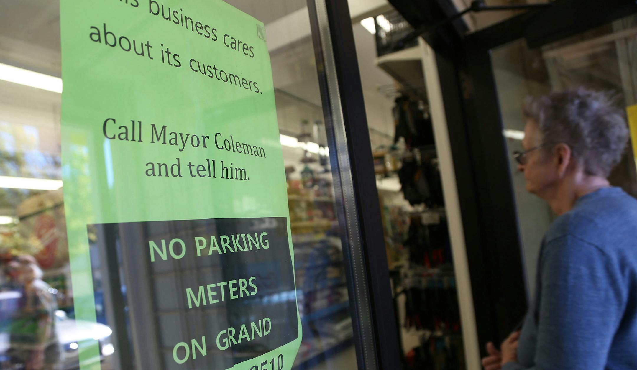 A customer walked into Frattelone Ace Hardware passed a sign that asked for support of no parking meters along Grand Ave. ] (KYNDELL HARKNESS/STAR TRIBUNE) kyndell.harkness@startribune.com On Grand Avenue in St Paul Min., Thursday October 1, 2015. St. Paul's plan to test metered parking on Grand Avenue, the city's best known commercial strip, has merchants and businesses seeing red. The council is expected to approve the measure in mid-October. ORG XMIT: MIN1510011719062041