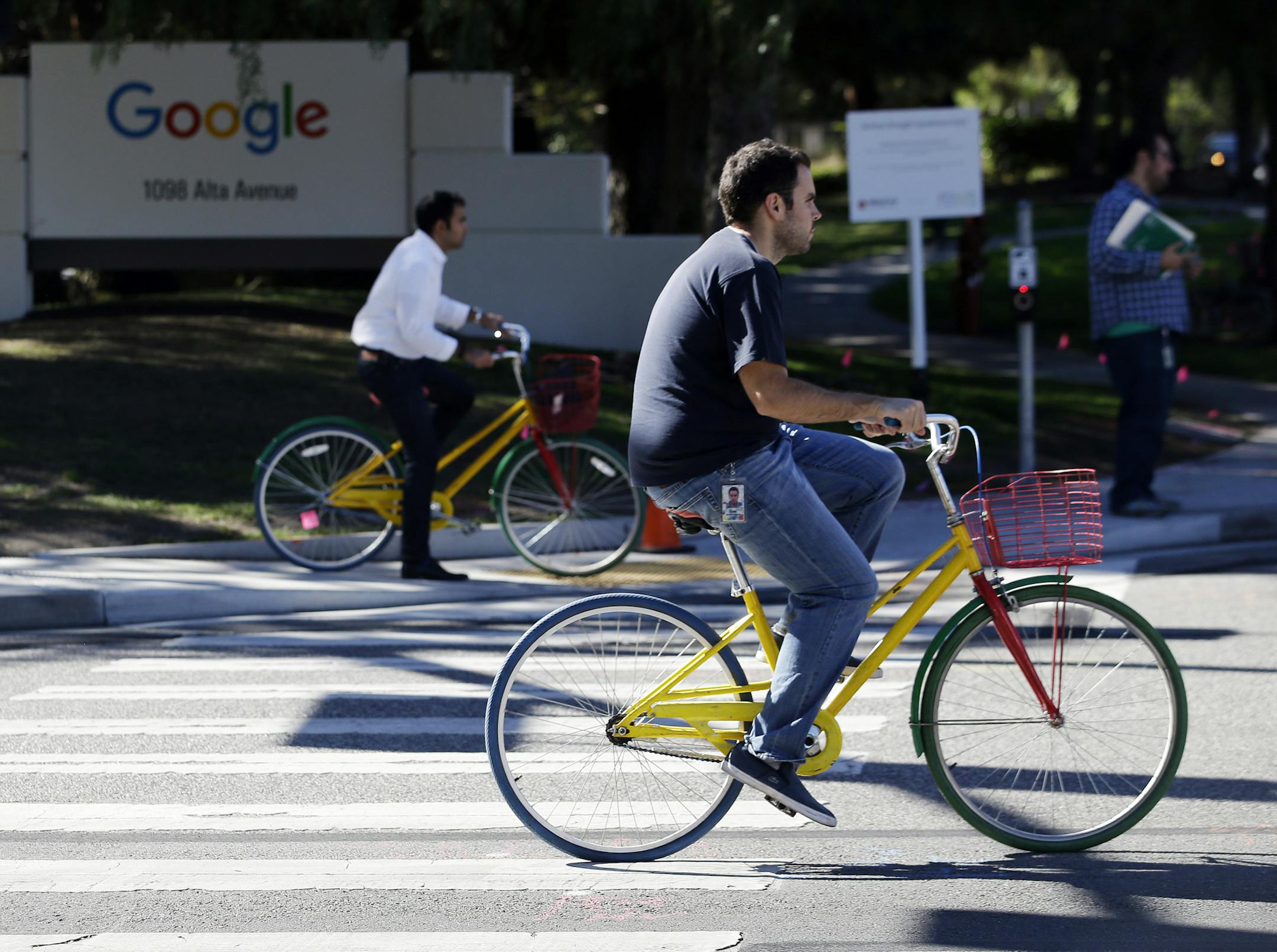 In this Oct. 20, 2015 photo, employees ride company bicycles outside Google headquarters in Mountain View, Calif. (AP Photo/Marcio Jose Sanchez) ORG XMIT: CAMS204