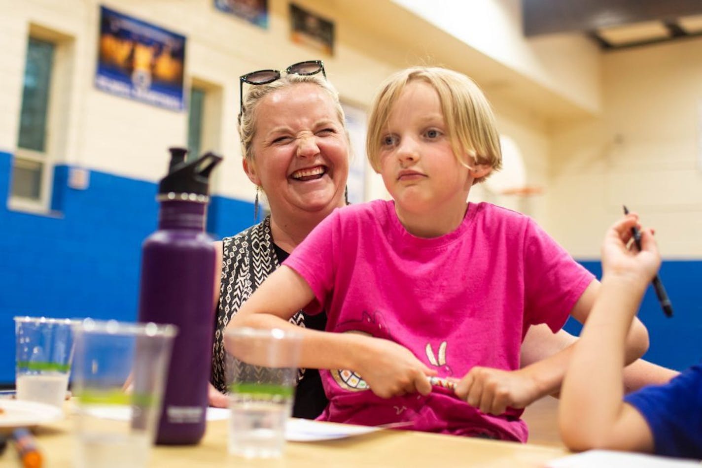 Folwell community member Heidi Nyquist laughs while holding her daughter, Emmy Nyquist, 8, during a community discussion and dinner in Folwell Recreation Center.