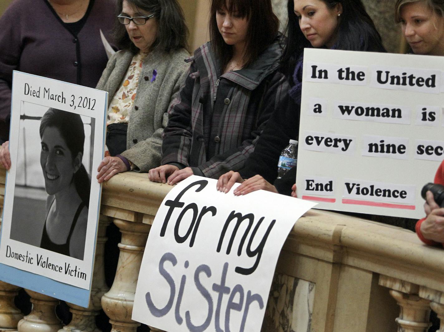 During the "Action Day" held by the Minnesota Coalition for Battered Women, Sheila Leete of St. Paul, left to right, Katie Tesmar of Coon Rapids, Samantha Phillippi of Oakdale and Della Bro of Roseville took in speakers below at the Capitol rotunda during a rally to protest violence against women Tuesday, March 12, 2013 in St. Paul, MN. Leete's daughter Carolyn Leete was killed by her boyfriend on March 3, 2013, and Phillippi has a sister her was hospitalized as a result of physical abuse.] (DAV
