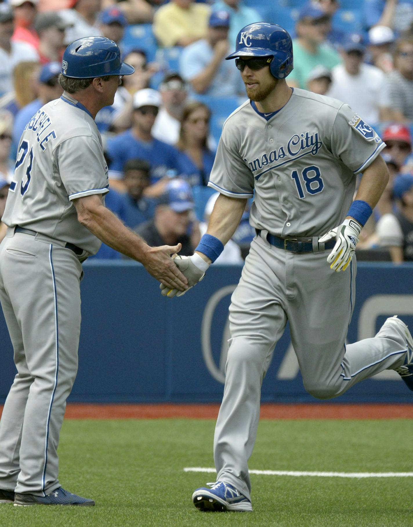 Kansas City Royals' Ben Zobrist, right, slaps hands with Royals' third base coach Mike Jirschele after hitting a solo home run against the Toronto Blue Jays during the first inning of a baseball game Saturday, Aug. 1, 2015, in Toronto. (Jon Blacker /The Canadian Press via AP) MANDATORY CREDIT