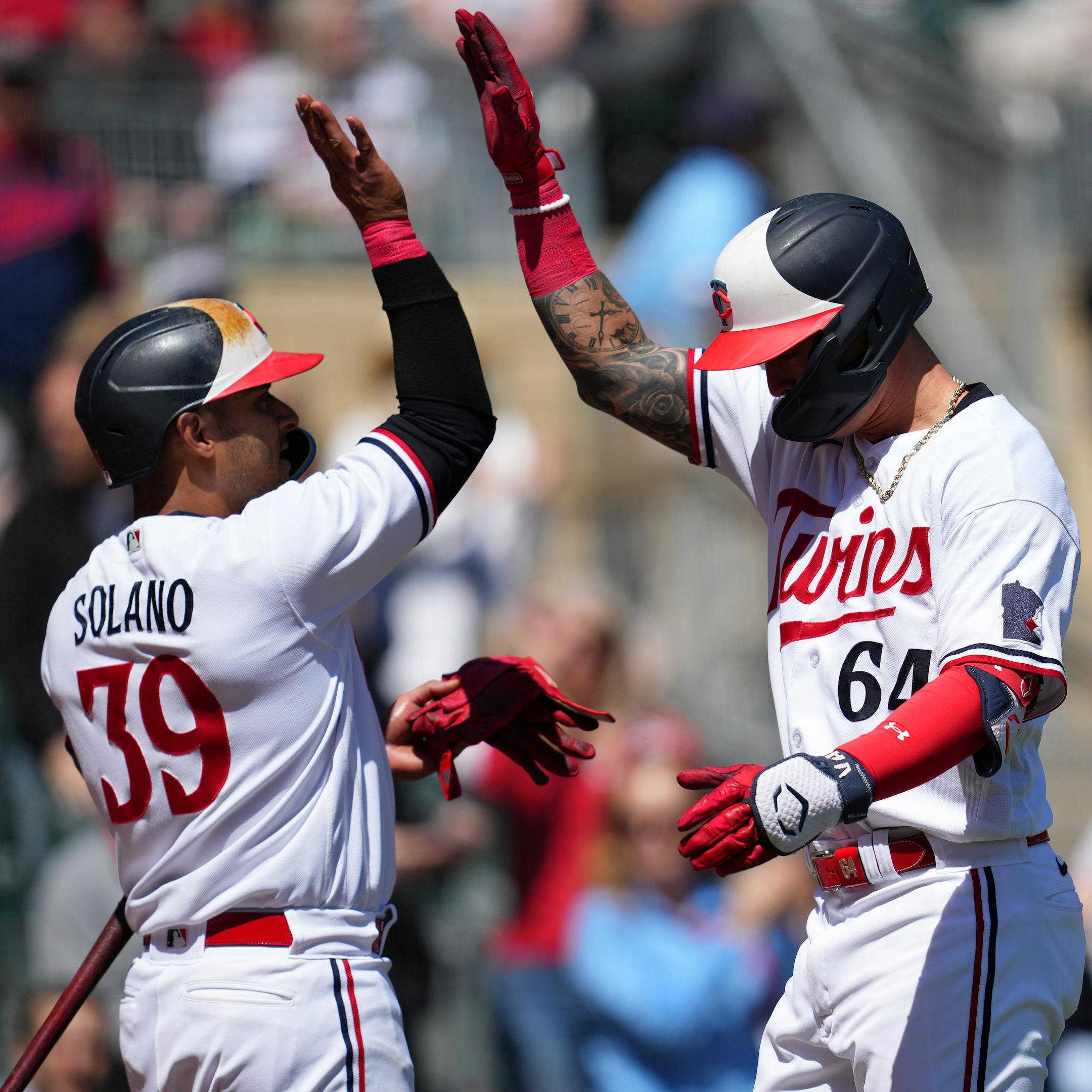 Minnesota Twins third baseman Jose Miranda (64) celebrates with Minnesota Twins first baseman Donovan Solano (39) after hitting a solo home run.
