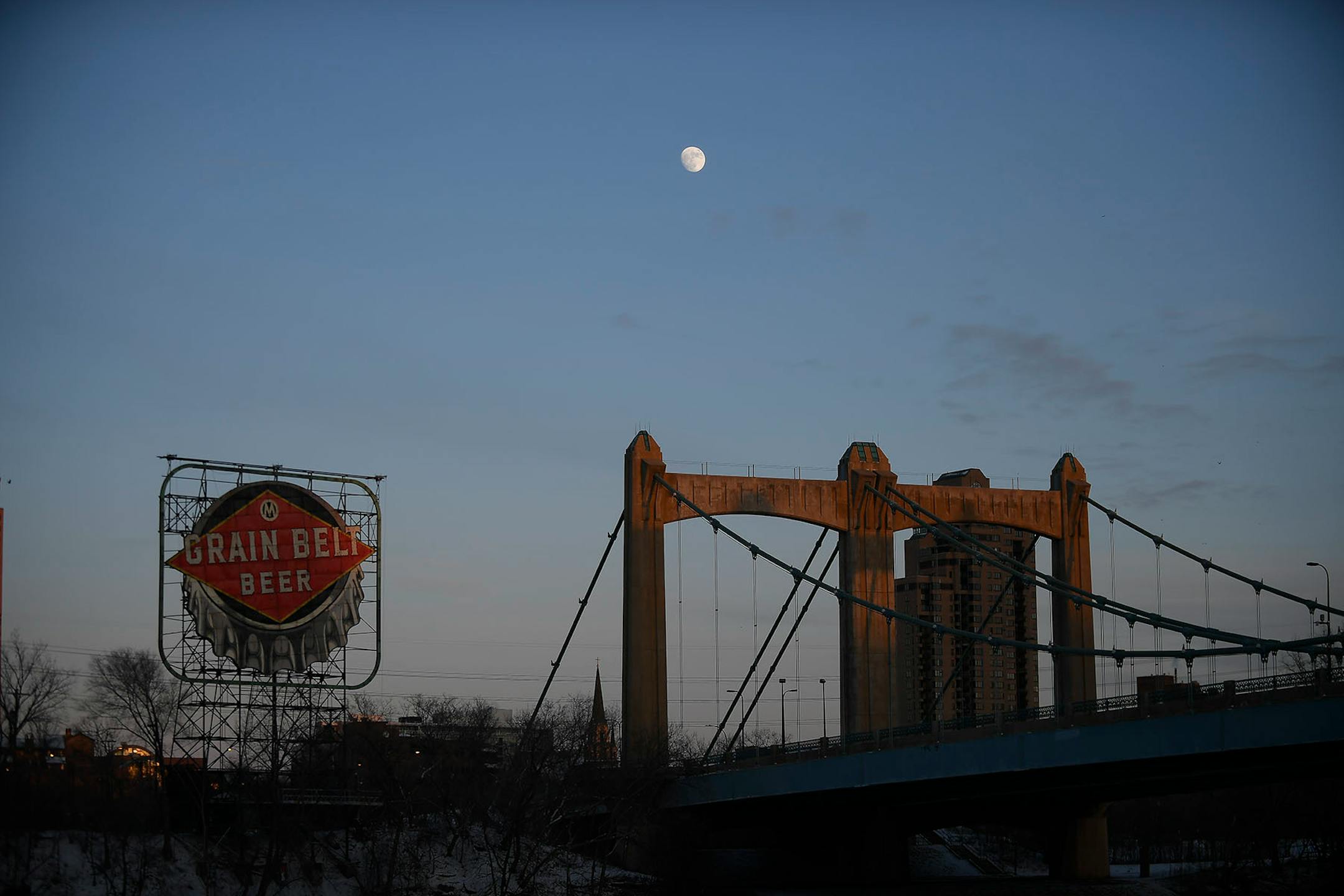 The moon rose from beyond the Grain Belt sign Saturday night before the sign's relighting ceremony.