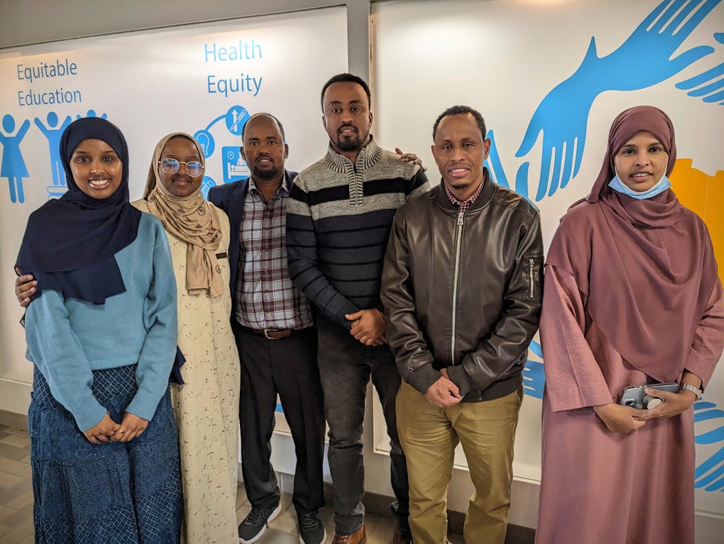 Center for African Immigrant and Refugee Organization Director Abdikadir Bashir, fourth from left, stands with nonprofit employees who focus on equitable education, workforce development, community health and housing.