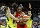 Las Vegas Aces' A'ja Wilson, center, fights for a loose ball with Seattle Storm's Sami Whitcomb, left, and Alysha Clark during the first half of a WNB