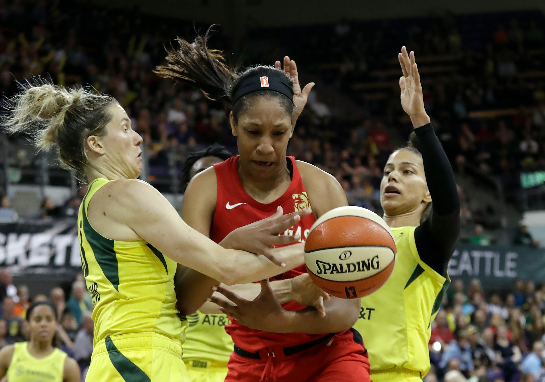 Las Vegas Aces' A'ja Wilson, center, fights for a loose ball with Seattle Storm's Sami Whitcomb, left, and Alysha Clark during the first half of a WNBA basketball game Friday, July 19, 2019, in Seattle. (AP Photo/Elaine Thompson)