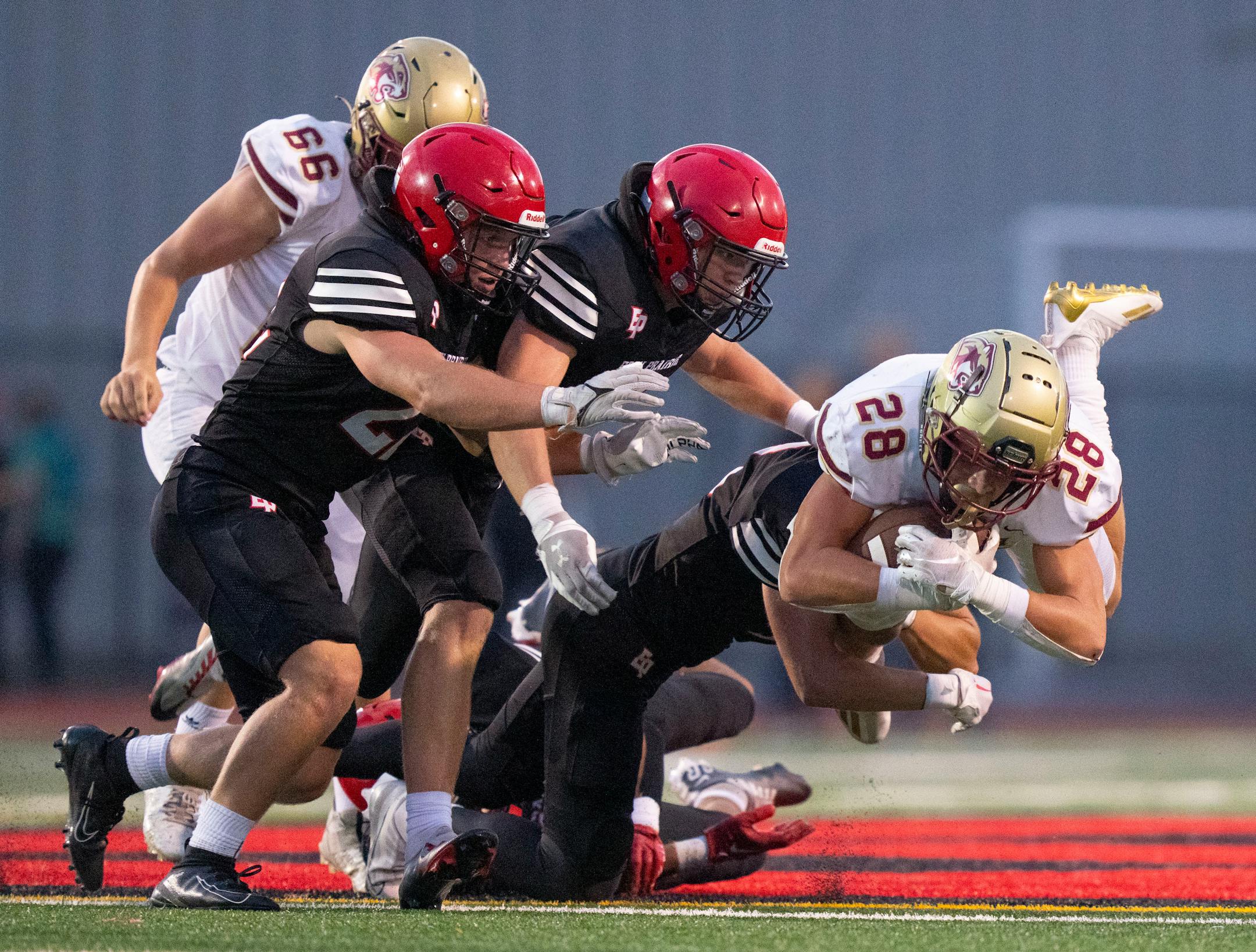 Lakeville South running back Carson Hansen (28) is gang tackled by Eden Prairie defenders in the second quarter Friday, September 16, 2022 at Eden Prairie High School in Eden Prairie, Minn. ]