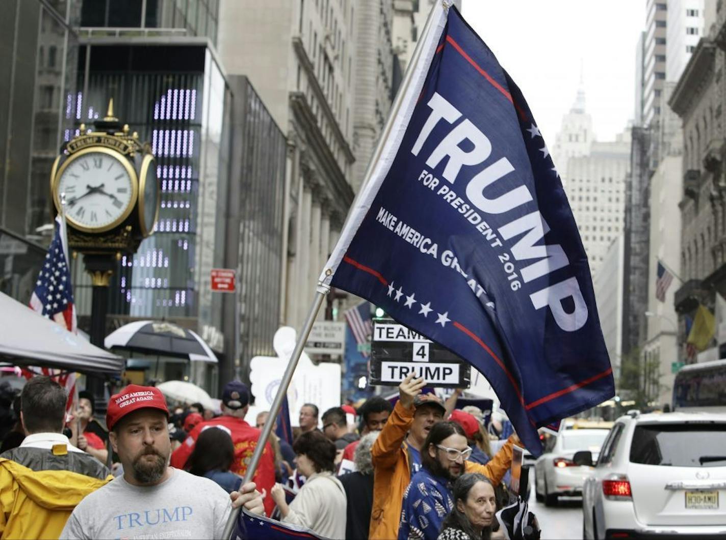 Supporters of Republican presidential nominee Donald Trump gather at Trump Tower on Saturday in New York. Trump insisted he would "never" abandon his White House bid but he faced an intensifying backlash from Republican leaders.