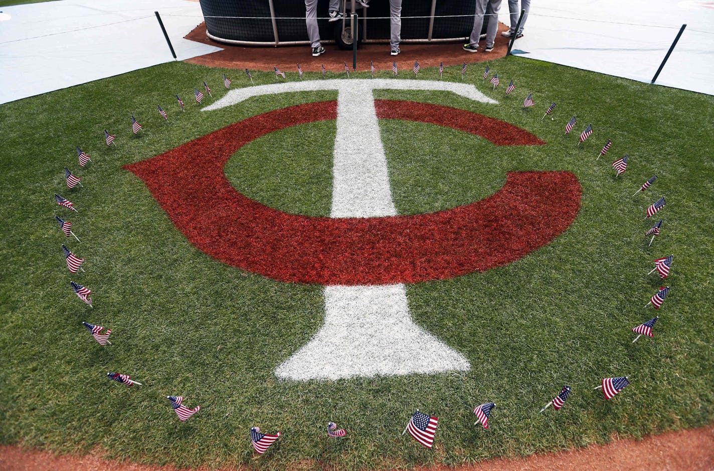 Flags marking the Fourth of July holiday surround the Minnesota Twins logo prior to a baseball game against the Oakland Athletics, Monday, July 4, 2016, in Minneapolis. (AP Photo/Jim Mone)