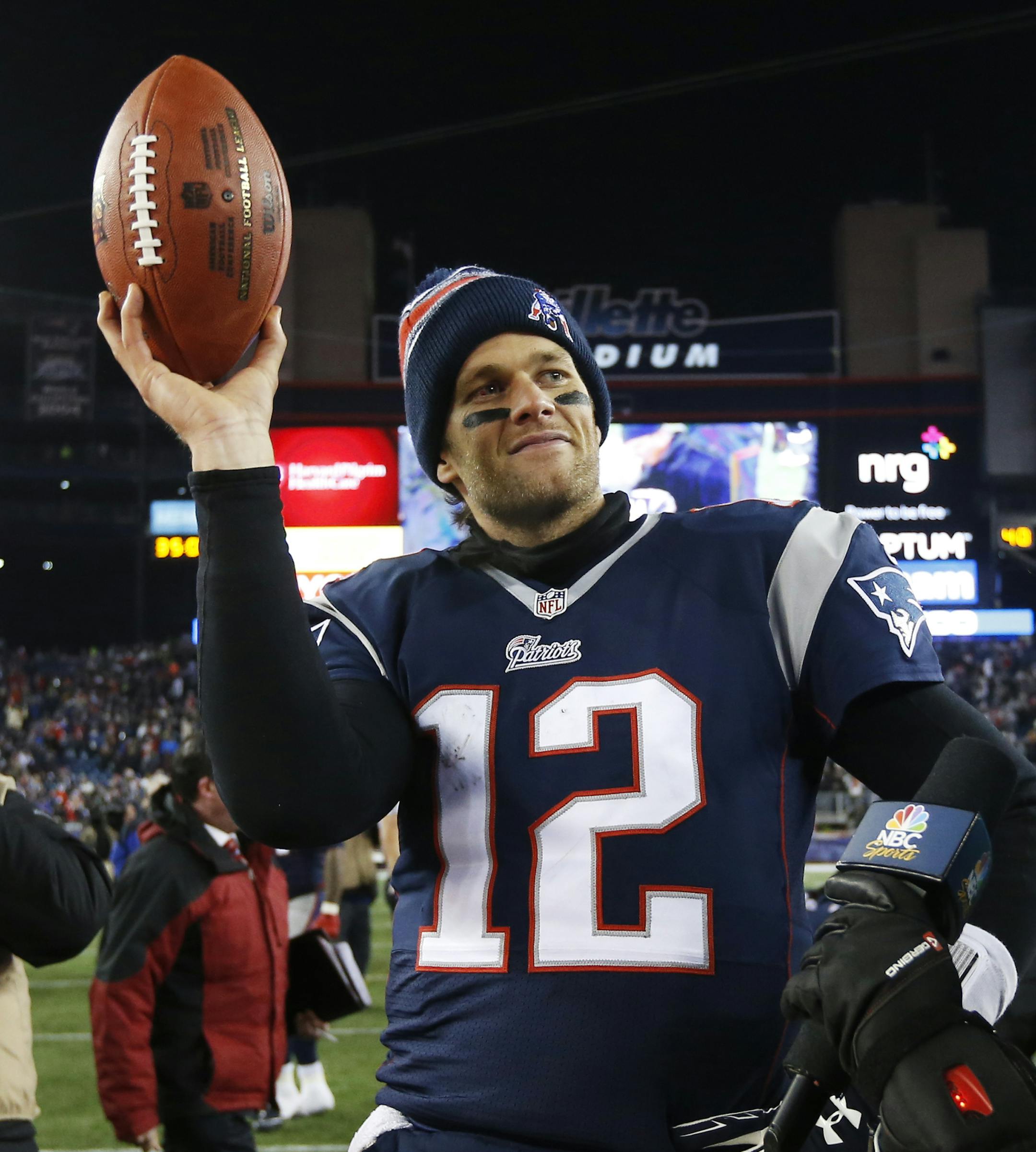 New England Patriots quarterback Tom Brady holds up the game ball after an NFL divisional playoff football game against the Baltimore RavensSaturday, Jan. 10, 2015, in Foxborough, Mass. The Patriots won 35-31 to advance to the AFC Championship game. (AP Photo/Elise Amendola)