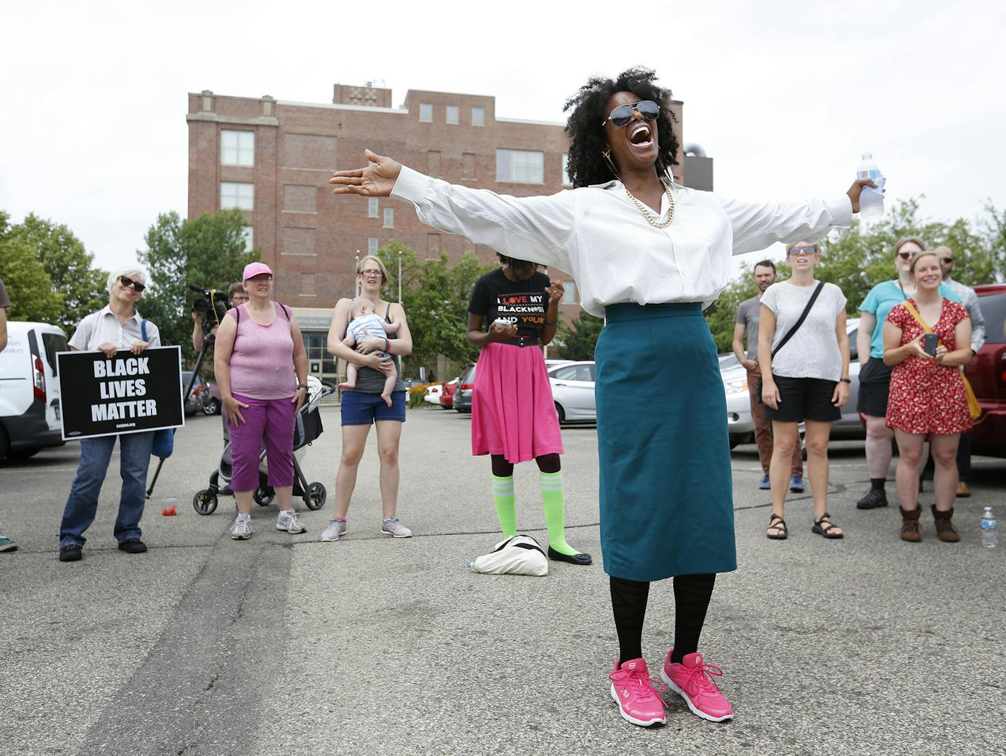 Singer Jayanthi Kyle leads a group in song outside the Ramsey County Law Enforcement Center in St. Paul. ] (Leila Navidi/Star Tribune) leila.navidi@startribune.com BACKGROUND INFORMATION: A group of about 50 people gathered outside the Ramsey County Law Enforcement Center on Monday, July 11, 2016 where they sang in support of the protesters who were jailed following Saturday night's protest march and freeway demonstration on I-94. Jayanthi Kyle's song &#x201c;Hand in Hand&#x201d; has become a pr