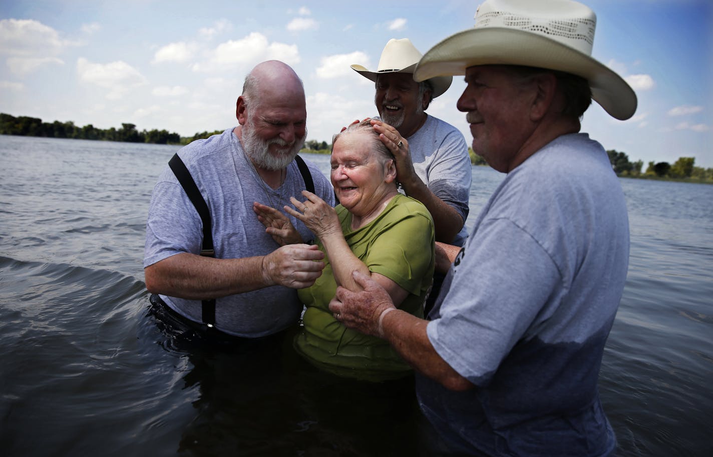 In Cambridge, Minnesota, elder Roger Nelson, pastor Joe Anderson, and Mike Swanson helped Sharon Jennen,76, come to Jesus during a water baptism where twelve people chose to be baptized the old fashioned way.]tsong-taataarii@startribune.com