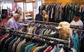 Shoppers, including Steve Aamodt, second from left, look through clothing at thrift store Local Imports in Shakopee.