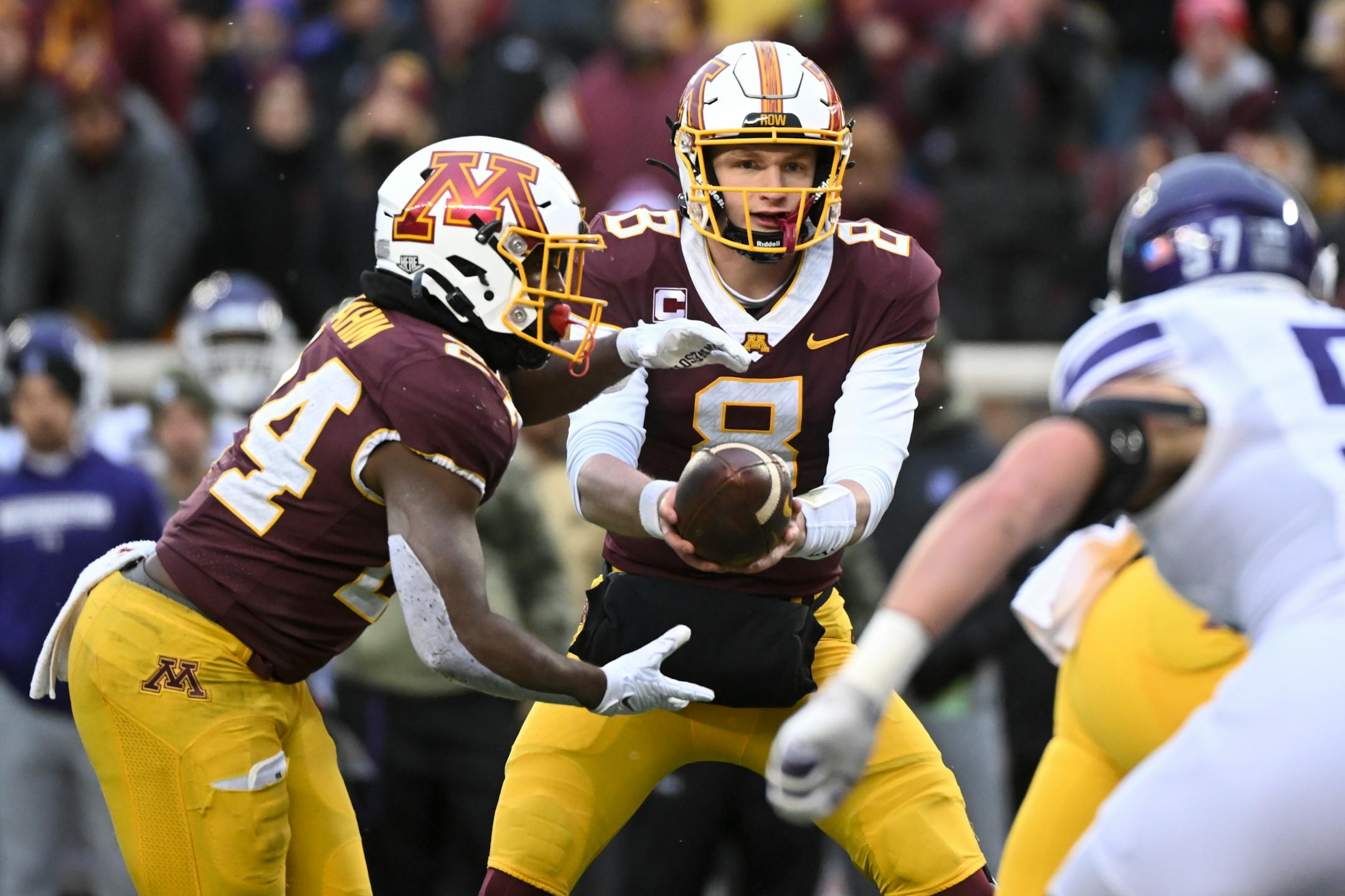 Minnesota Gophers quarterback Athan Kaliakmanis (8) hands off the ball to running back Mohamed Ibrahim (24) during the first half.
