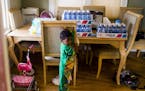 Cases of bottled water rest on the dining room table next to 3-year-old Demetrius Lanier on Monday, Feb. 1, 2016 in his home on the west side of Flint