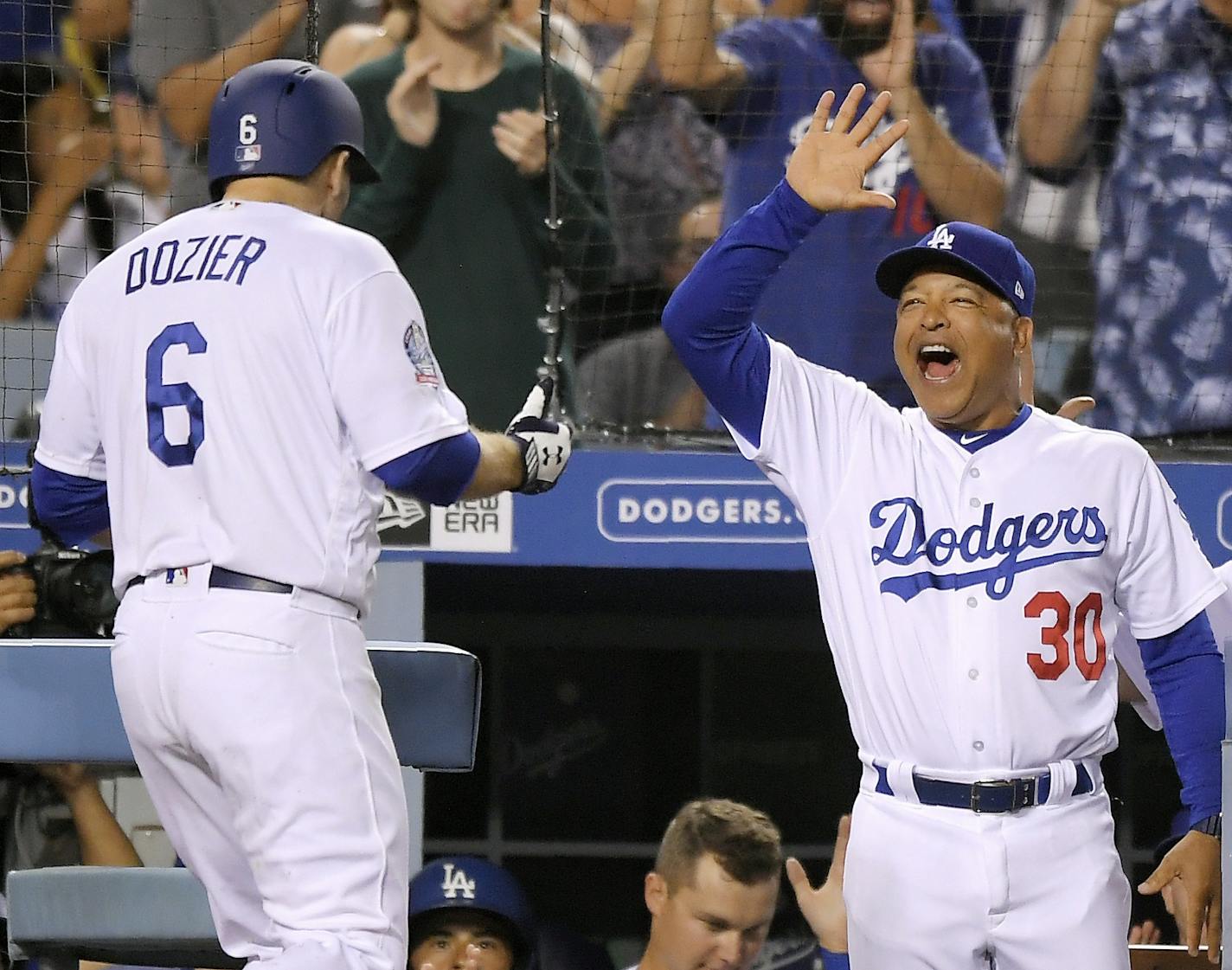 Los Angeles Dodgers' Brian Dozier, left, is congratulated by manager Dave Roberts after hitting a solo home run during the fifth inning of the team's baseball game against the Milwaukee Brewers on Wednesday, Aug. 1, 2018, in Los Angeles. (AP Photo/Mark J. Terrill)