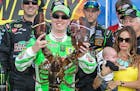 Kyle Busch held the Loudon lobster trophy in Victory Lane, as his wife, Samantha (right, holding son Brexton) looked on, after winning the NASCAR Spri