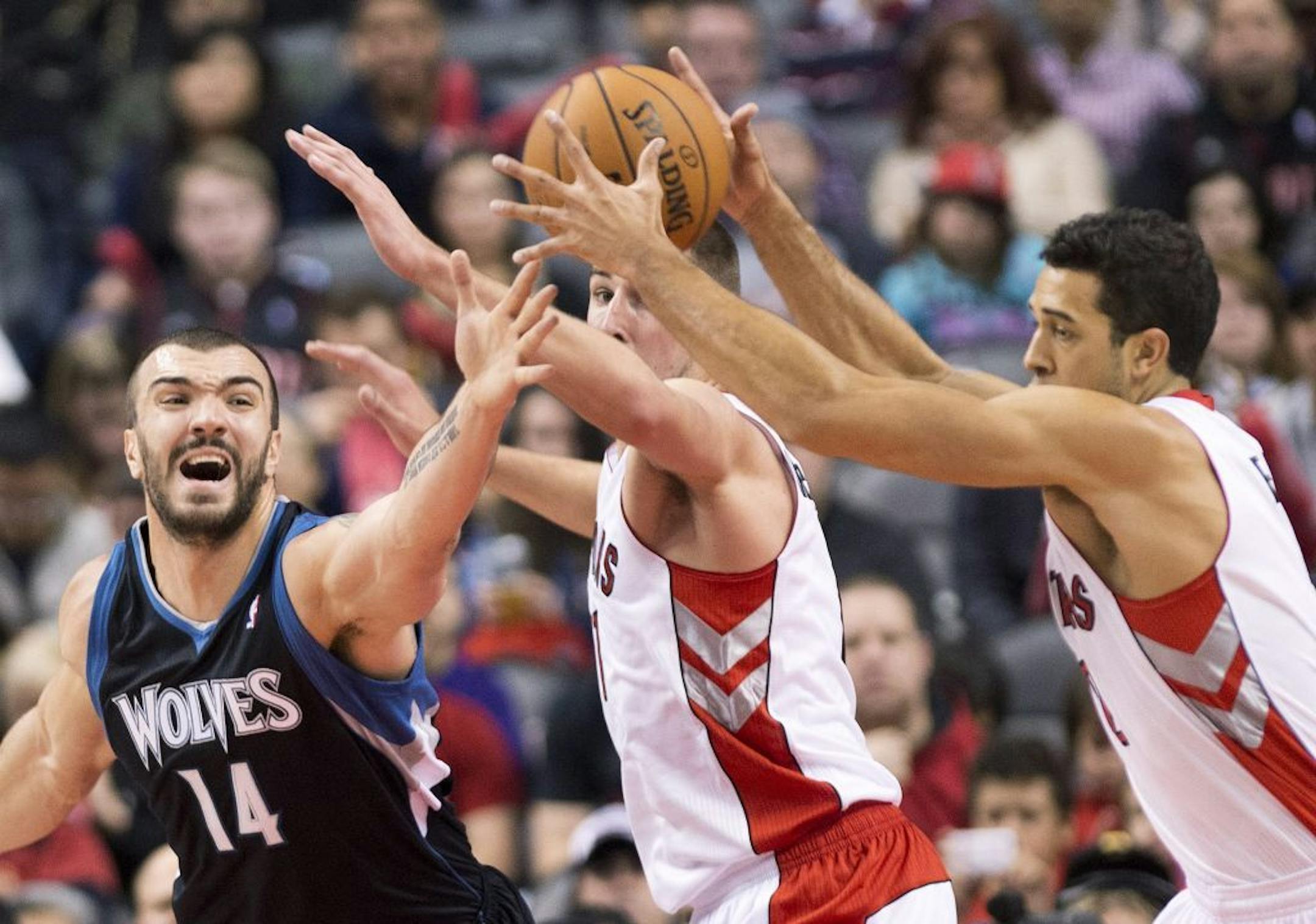 Toronto Raptors forwards Landry Fields, right, and Jonas Valanciunas, center, battled for the ball against Timberwolves center Nikola Pekovic during first-half action in Toronto on Sunday.