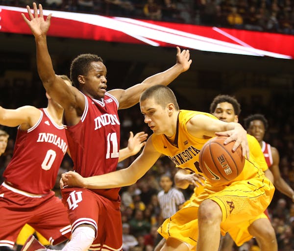 The University of Minnesota's Joey King (24) tries to drive around the University of Indiana's Kevin Yogi Ferrell (11) during the second half of the G