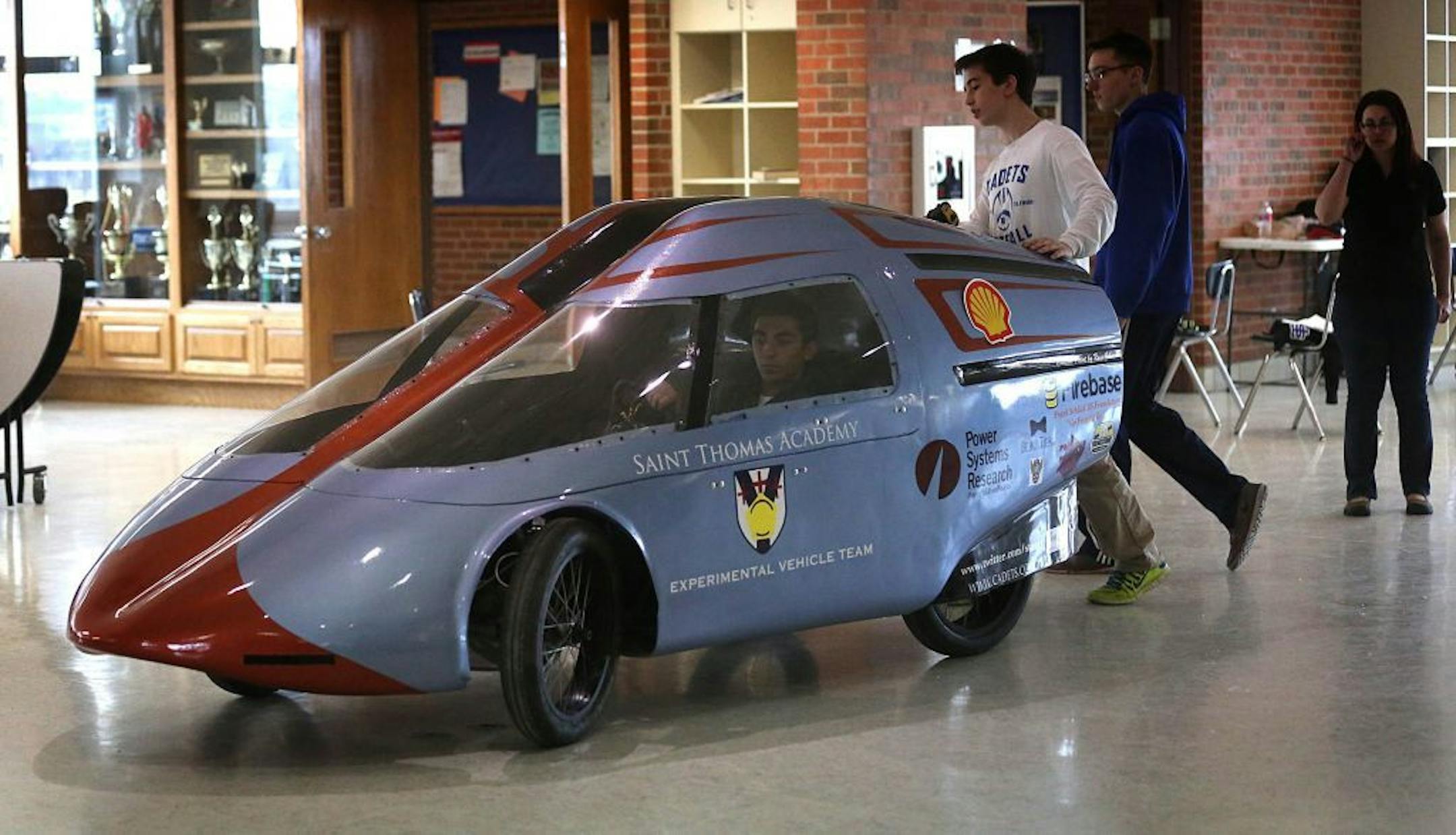 Patrick Gayord, left, and John Ingebrigtsen pushed the experimental car as faculty adviser Caroline Little monitored the work. Behind the wheel is Tim D'Agostino.