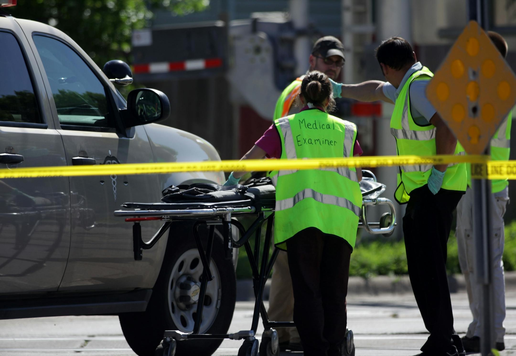 The Medical examiner readies a stretcher at the scene.