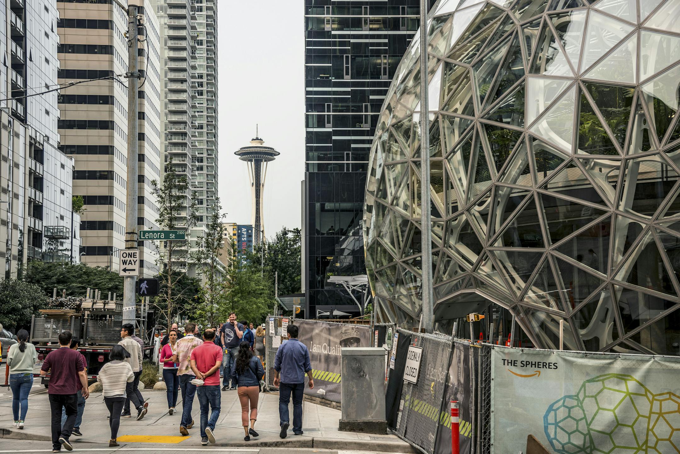 With the Space Needle observation tower visible in the distance, pedestrians walk past a recently built trio of geodesic domes that are part of the Seattle headquarters for Amazon, Sept. 7, 2017. The online retail giant said it was searching for a second headquarters in North America in 2017, a huge new development that would cost as much as $5 billion to build and run, and house as many as 50,000 employees. (Stuart Isett/The New York Times)