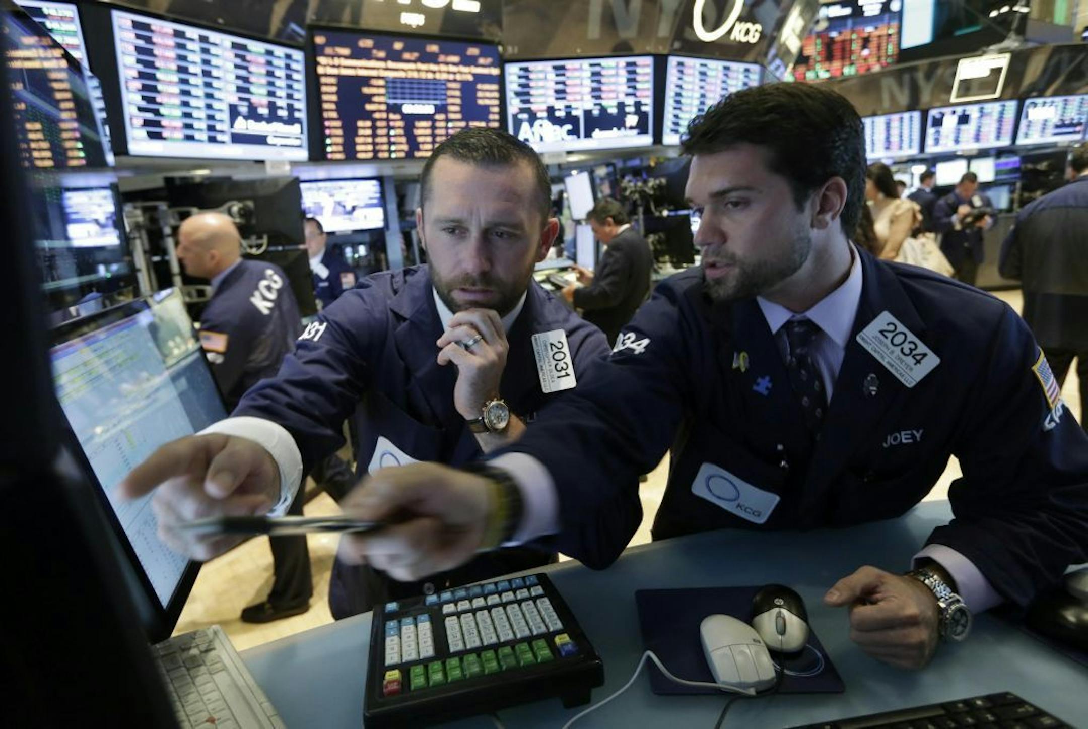 Specialists Christopher Gildea, left, and Joseph Dreyer, confer at their posts on the floor of the New York Stock Exchange Monday, July 22, 2013. The stock market is opening mixed after McDonald's reported poor quarterly earnings.