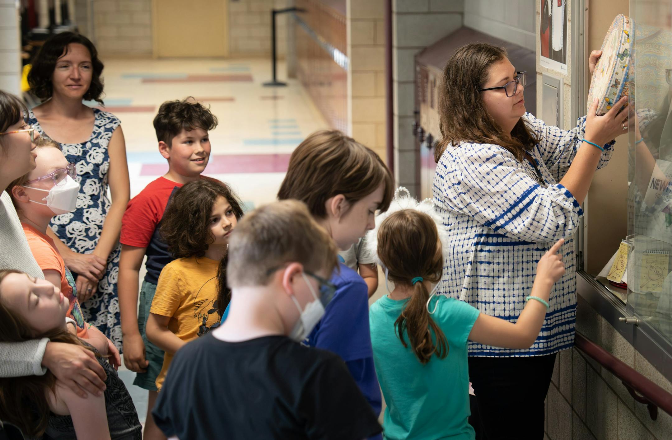 Principal Jessie Lavintman replaced the time capsule into its temporary display after the students had the chance to look inside one more time Friday, June 2, 2023 St. Paul, Minn. Students at the Newman School — part of Talmud Torah, a Jewish day school in St. Paul — built a time capsule on Friday. After learning about the history of the founders of their school, they're sending a little bit of their own history into the future.