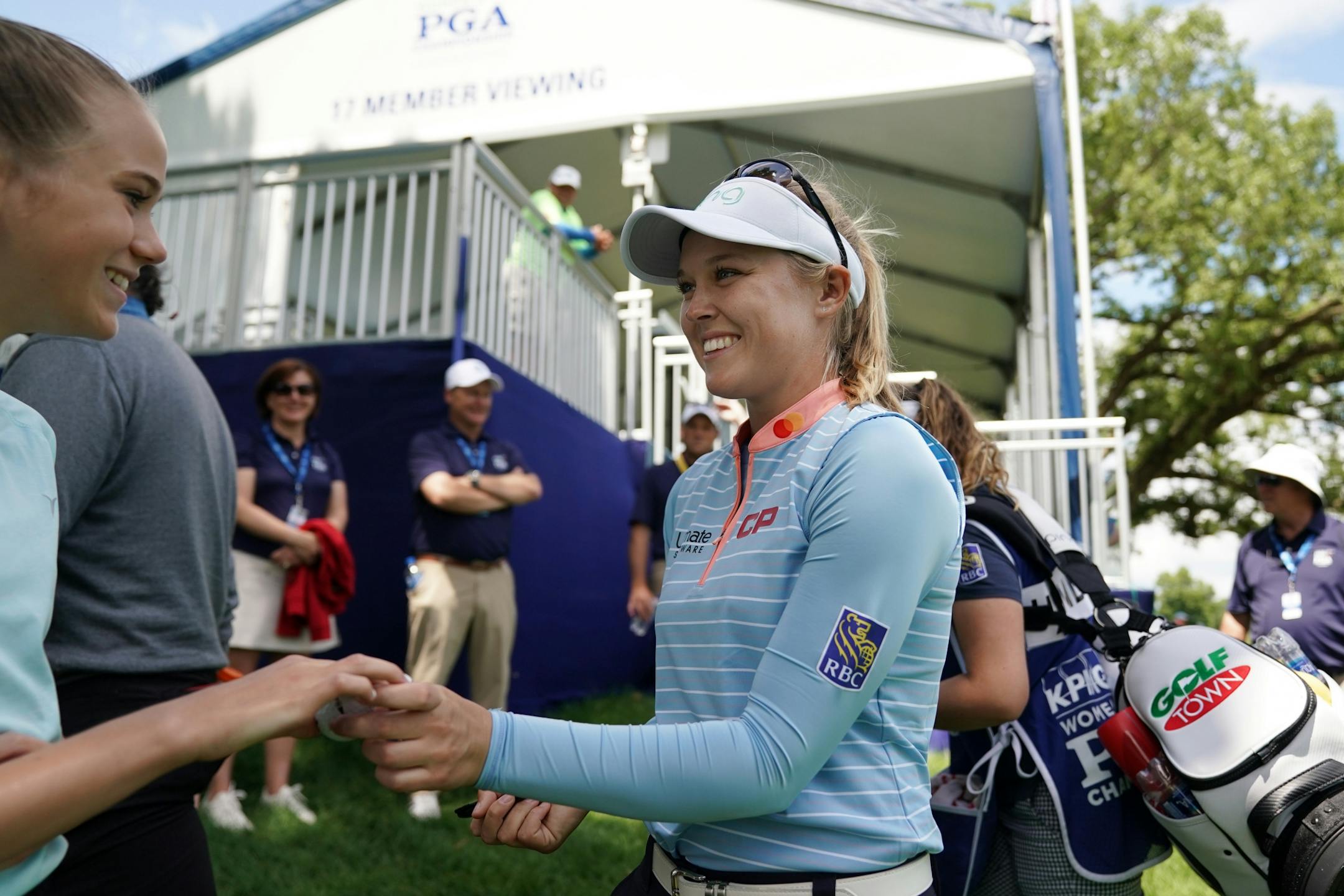 Brooke Henderson signed autographs for fans as she walked between holes Tuesday afternoon.