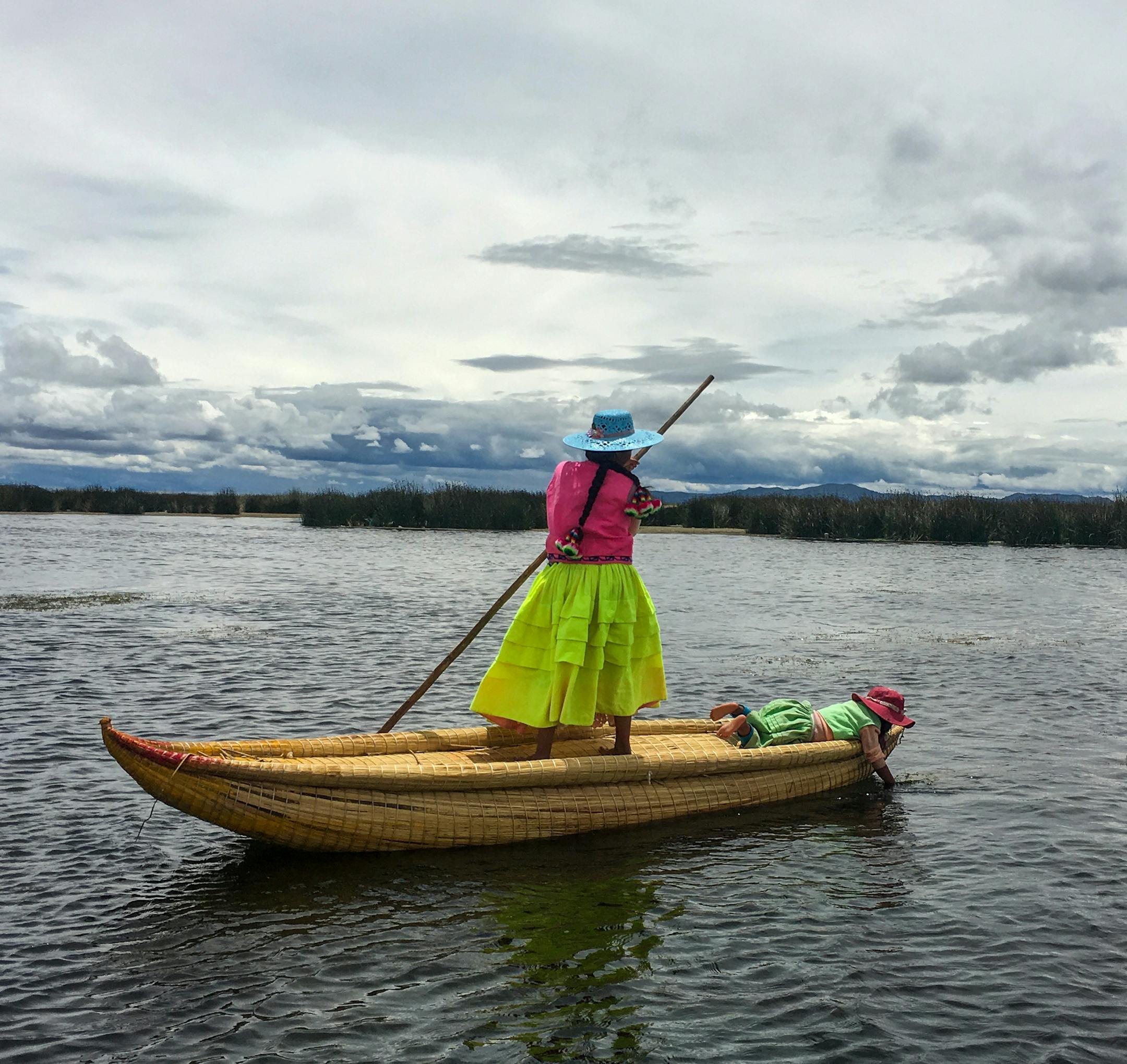 LAKE TITICACA, PERU - A young woman poles through the shallow waters of Lake Titicaca. Although the lake is nearly 1,000 feet deep, the Uros live close to the shoreline where the reeds grow and the lake is no more than 10 feet deep. (Thomas Curwen/TNS) ORG XMIT: 1504055