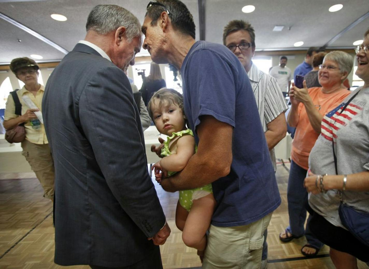 With his 13-month-old granddaughter Pieta in his arms, Leroy Dombrovski spoke to Gov. Mark Dayton in Rochester on Wednesday. Dayton was there to talk about health funding and the budget standoff.