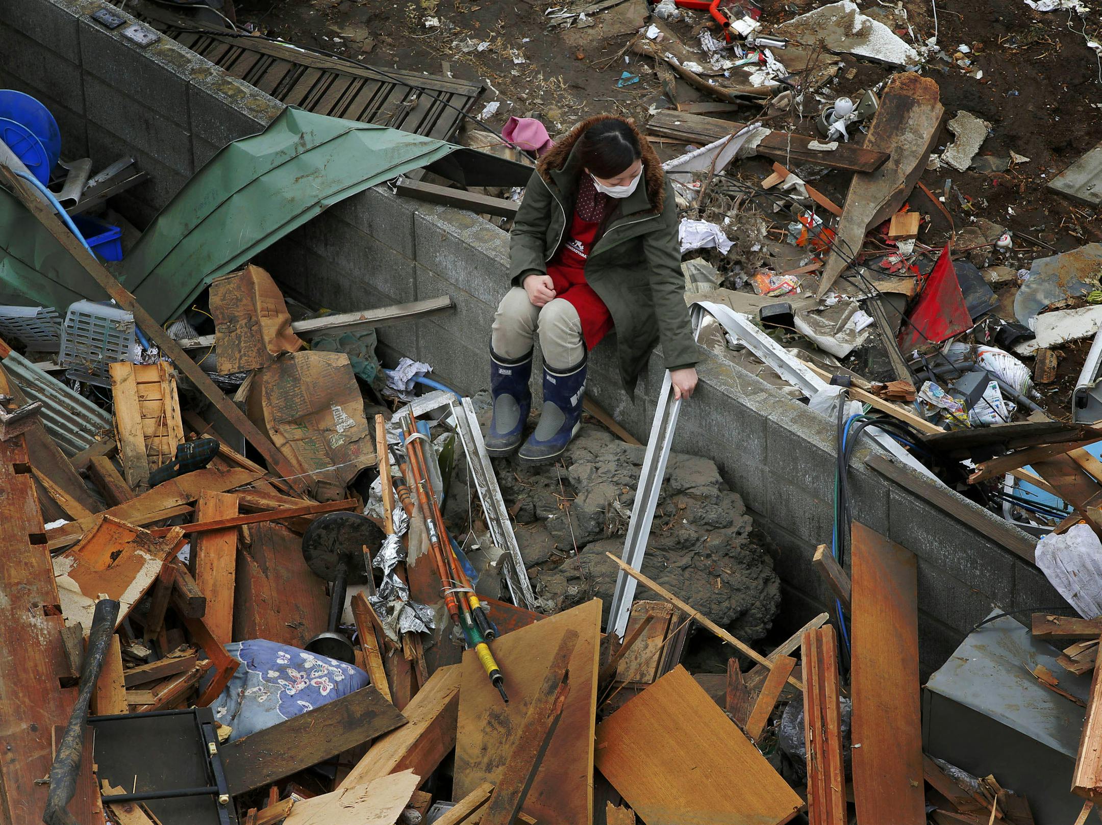 A woman sat on a wall in the tsunami-hit residential area of Ofunato, Japan, on March 15, 2011, four days after the disaster.