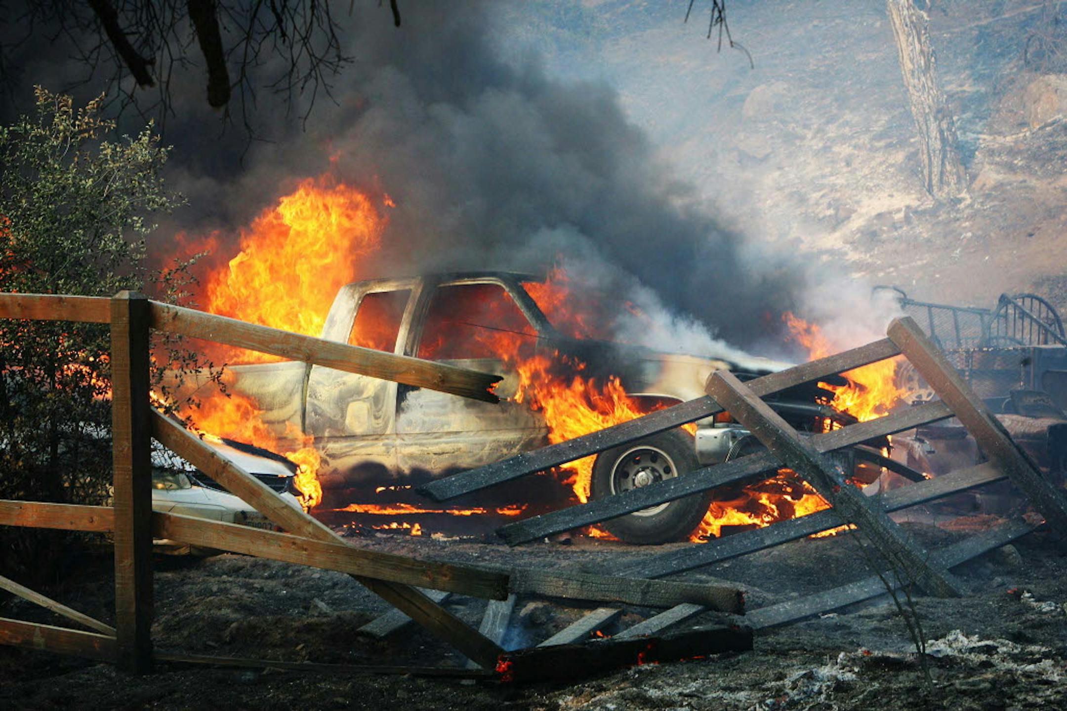 A pickup truck is engulfed in flames as the Silver Fire roars through a residential area near Hwy 243 and Twin Pines Road between Banning and Idyllwild, Calif. on Wednesday.
