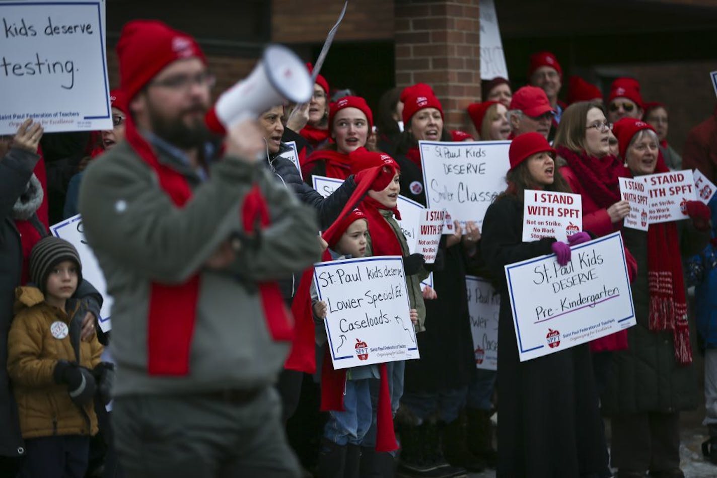 Hundreds of teachers, children, parents and supporters of the St. Paul Federation of Teachers chanted while holding signs, many wearing red, in front of the St. Paul school district headquarters Tuesday, February 18, 2014, in St. Paul, Minn., before the school board meeting where discussions of class sizes, teacher's pay and more as the possibility of a teacher strike looms.