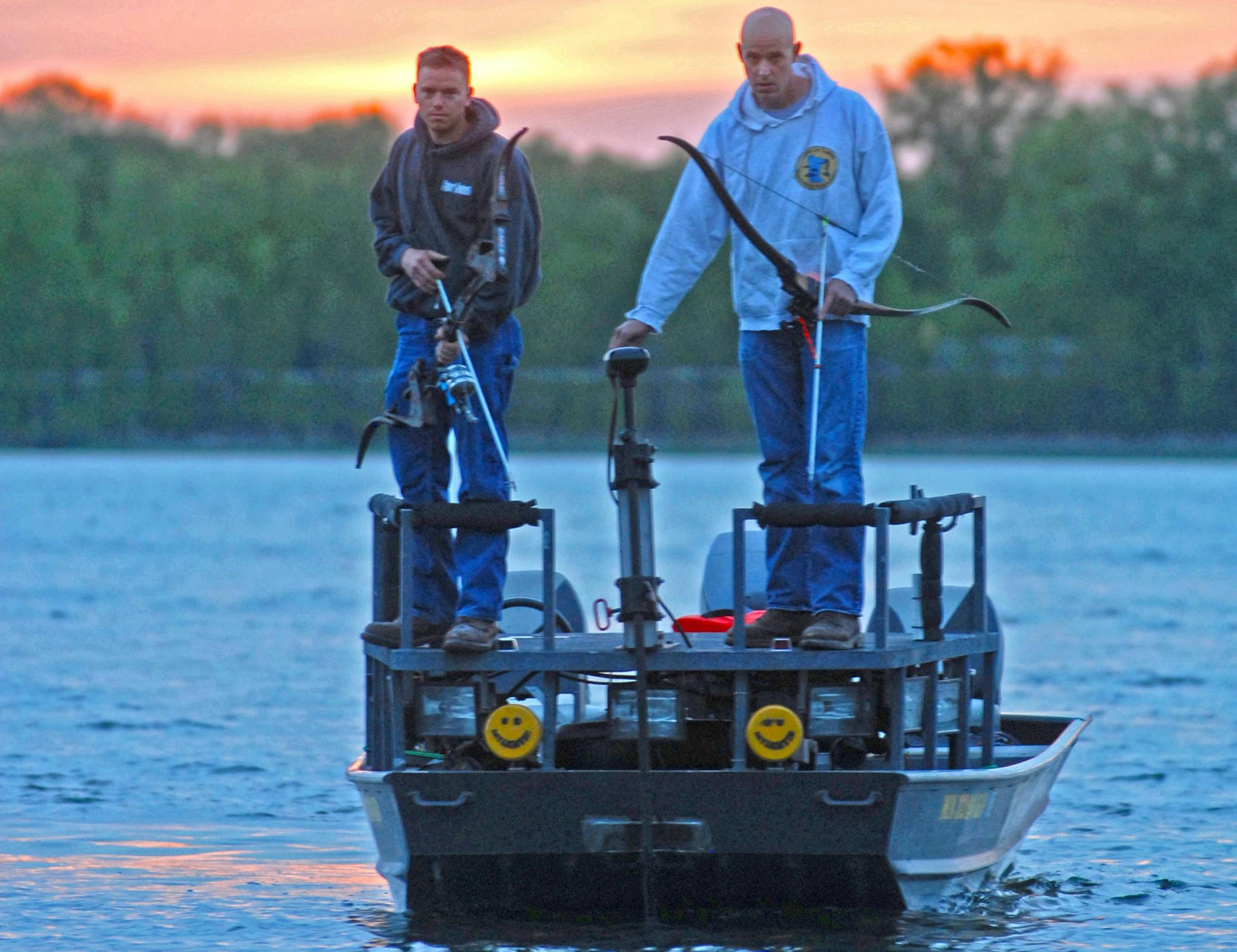 Carl Sassen, left, of Lexington, and Patrick Kirschbaum of Andover prepared to cruise Little Green Lake near Chisago City on Tuesday night, bowfishing for carp.