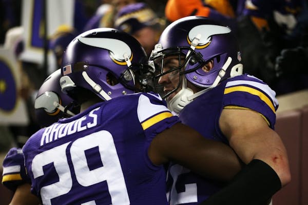 Vikings cornerback Xavier Rhodes embraces safety Harrison Smith after Smith ran 35 yards for a second quarter touchdown after intercepting a pass from