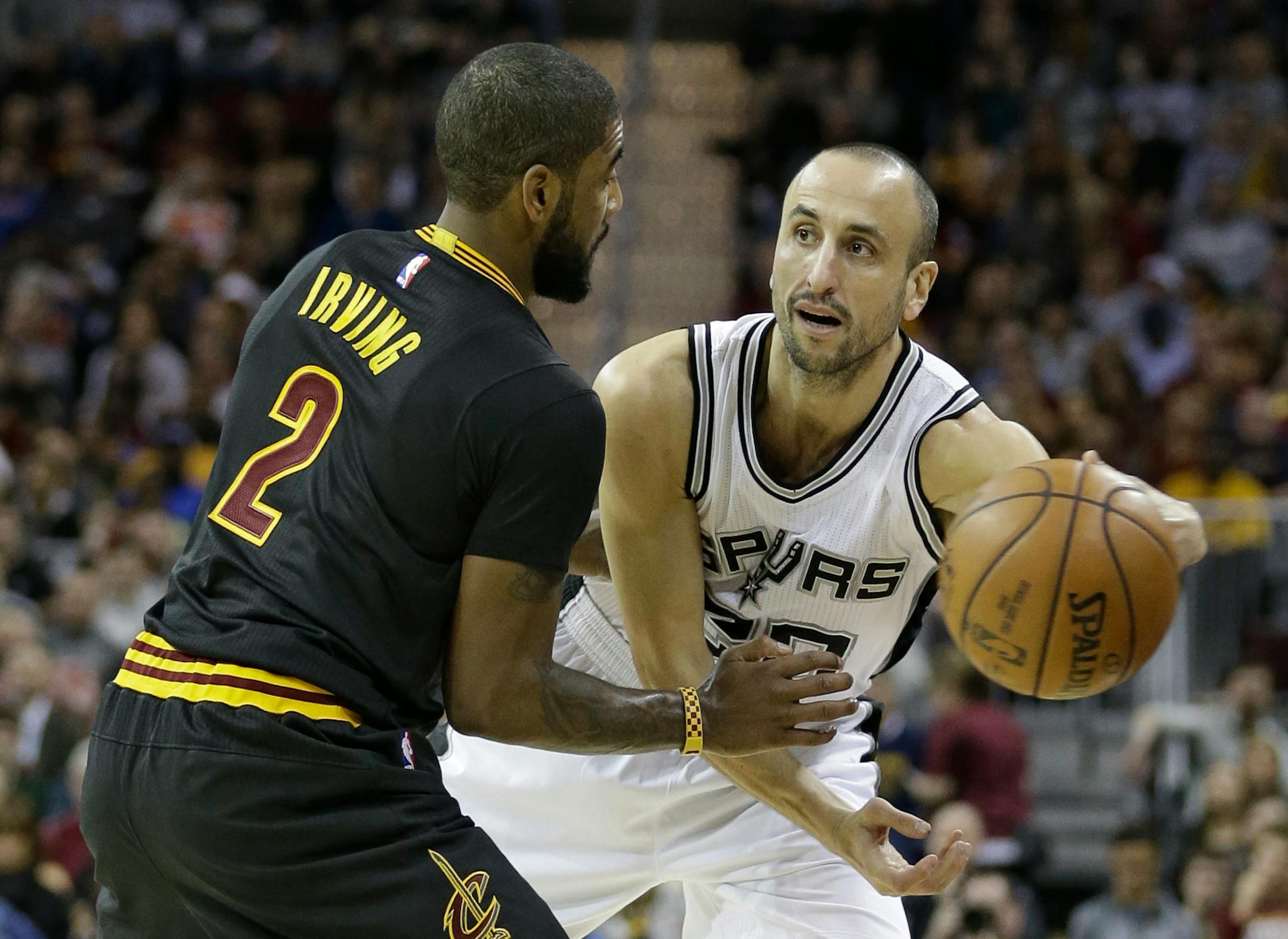 San Antonio Spurs' Manu Ginobili, right, from Argentina, passes around Cleveland Cavaliers' Kyrie Irving in the first half of an NBA basketball game, Saturday, Jan. 21, 2017, in Cleveland. (AP Photo/Tony Dejak)