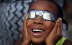 William Ndegwa 7, yelled "I can see it" as he watched a partial eclipse with his mom Maureen Ndegwa at the Science Museum of Minnesota Monday August 2